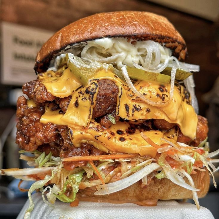 Asian inspired fried chicken burger with cheese, pickles and vegetables from SHIO